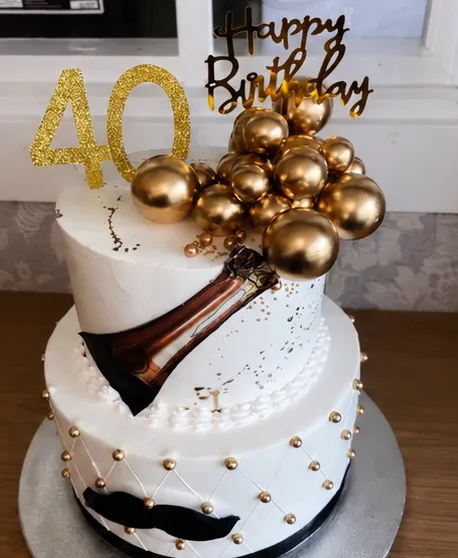 A white and gold two-tier 40th birthday cake